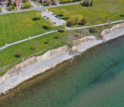 Drone photo of the shoreline near Love Crescent and Lake Driveway W showing erosion damage near the parking lot and Waterfront Trail. 